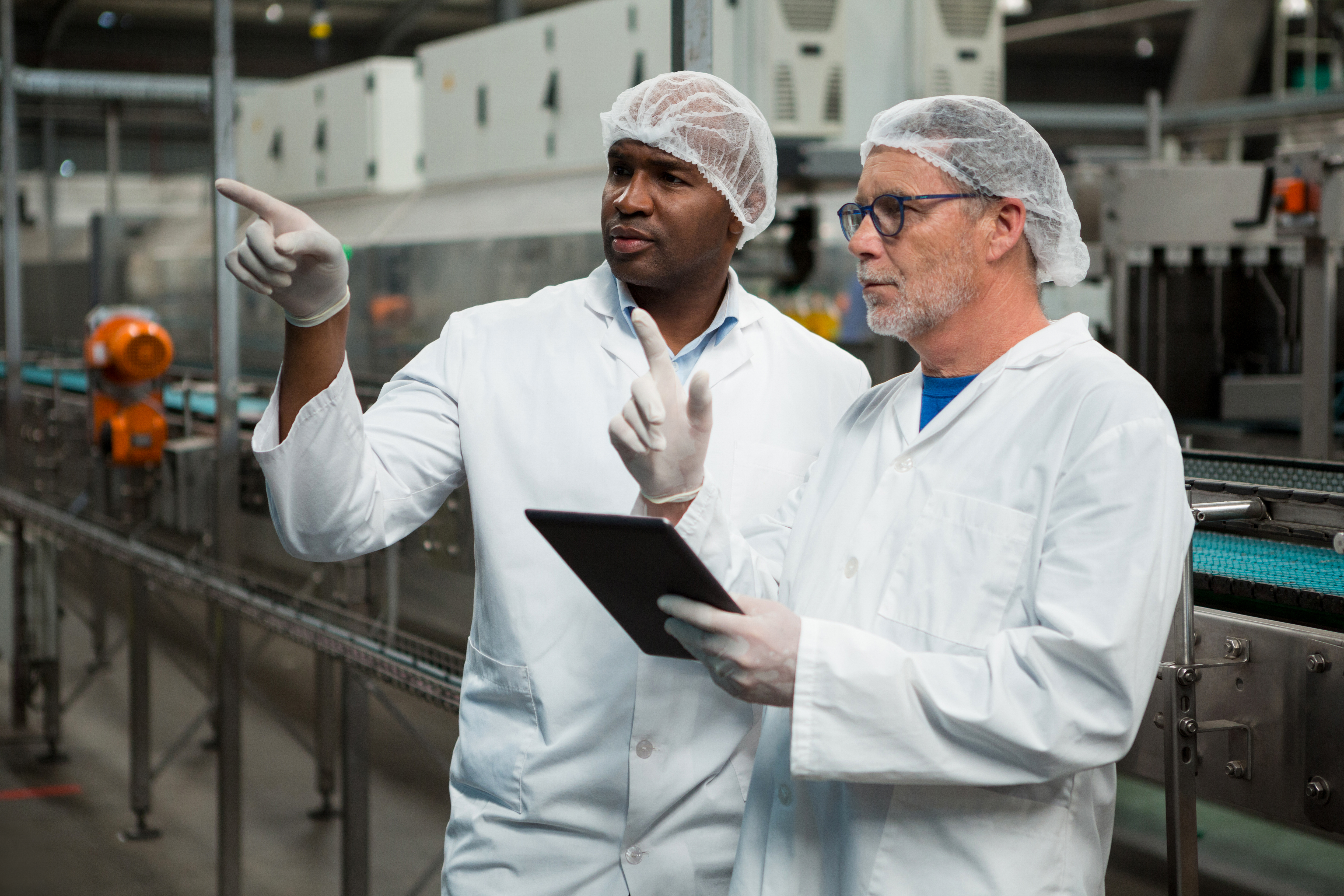 Male workers inspecting products in cold drink factory